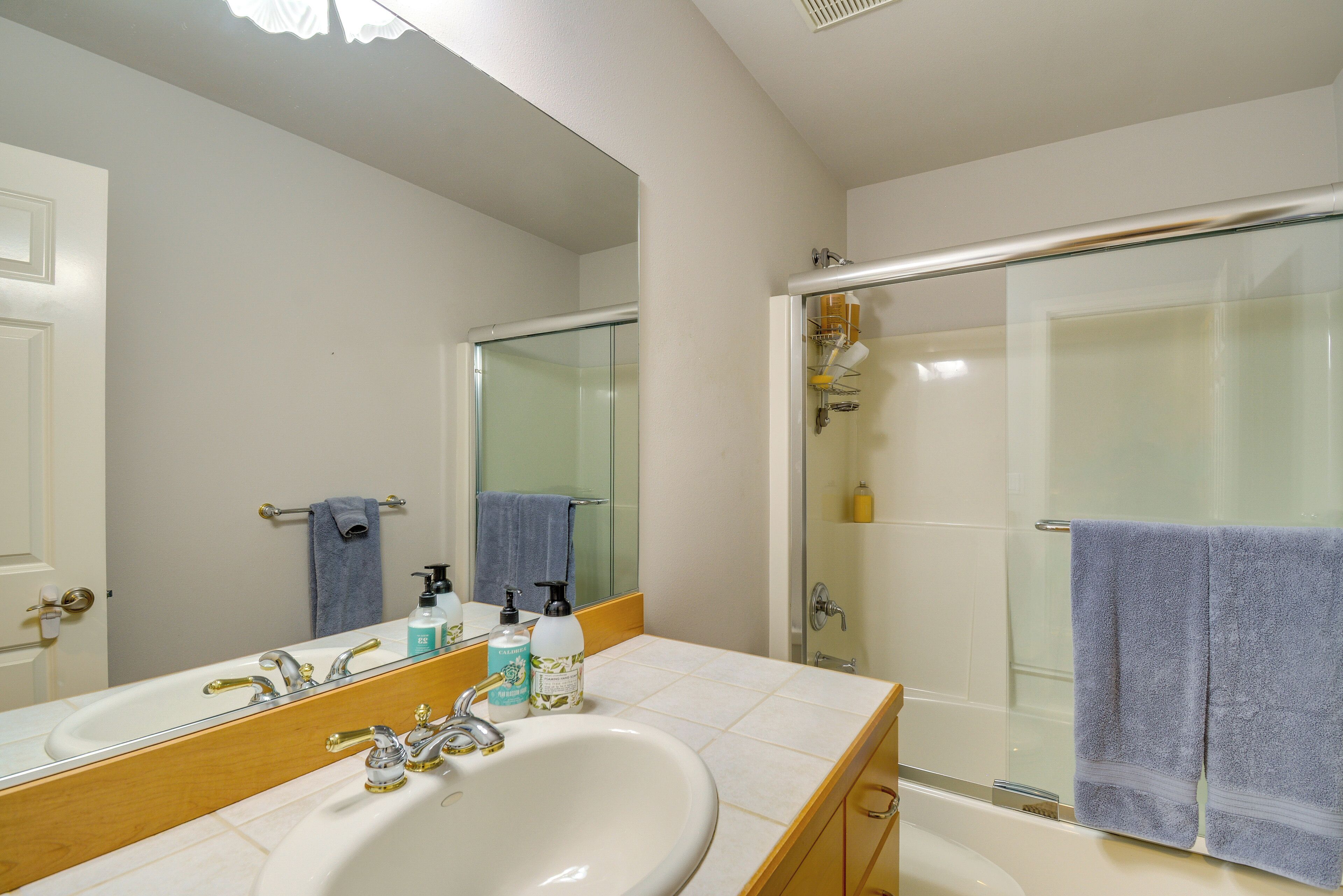 Une salle de bain avec un lavabo, un miroir et une douche.