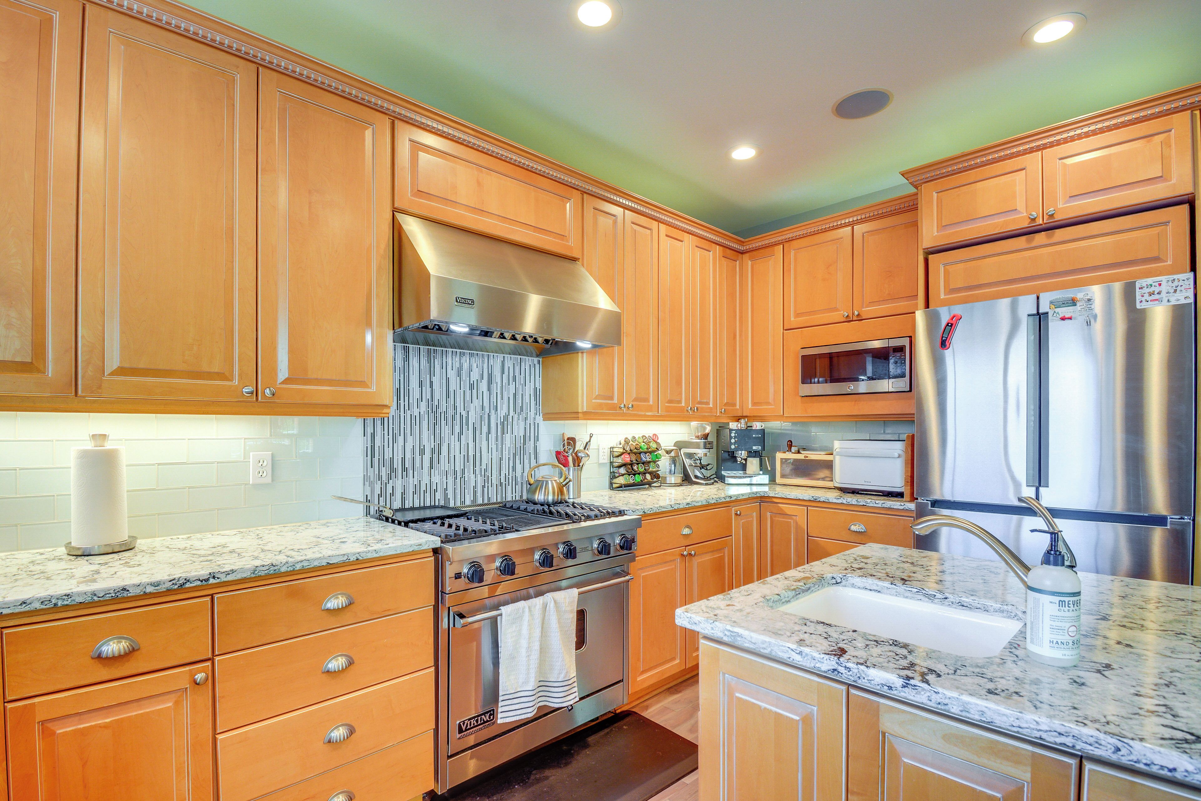 A kitchen with wooden cabinets, a stainless steel stove, and a refrigerator.