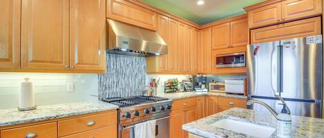 A kitchen with wooden cabinets, a stainless steel stove, and a refrigerator.