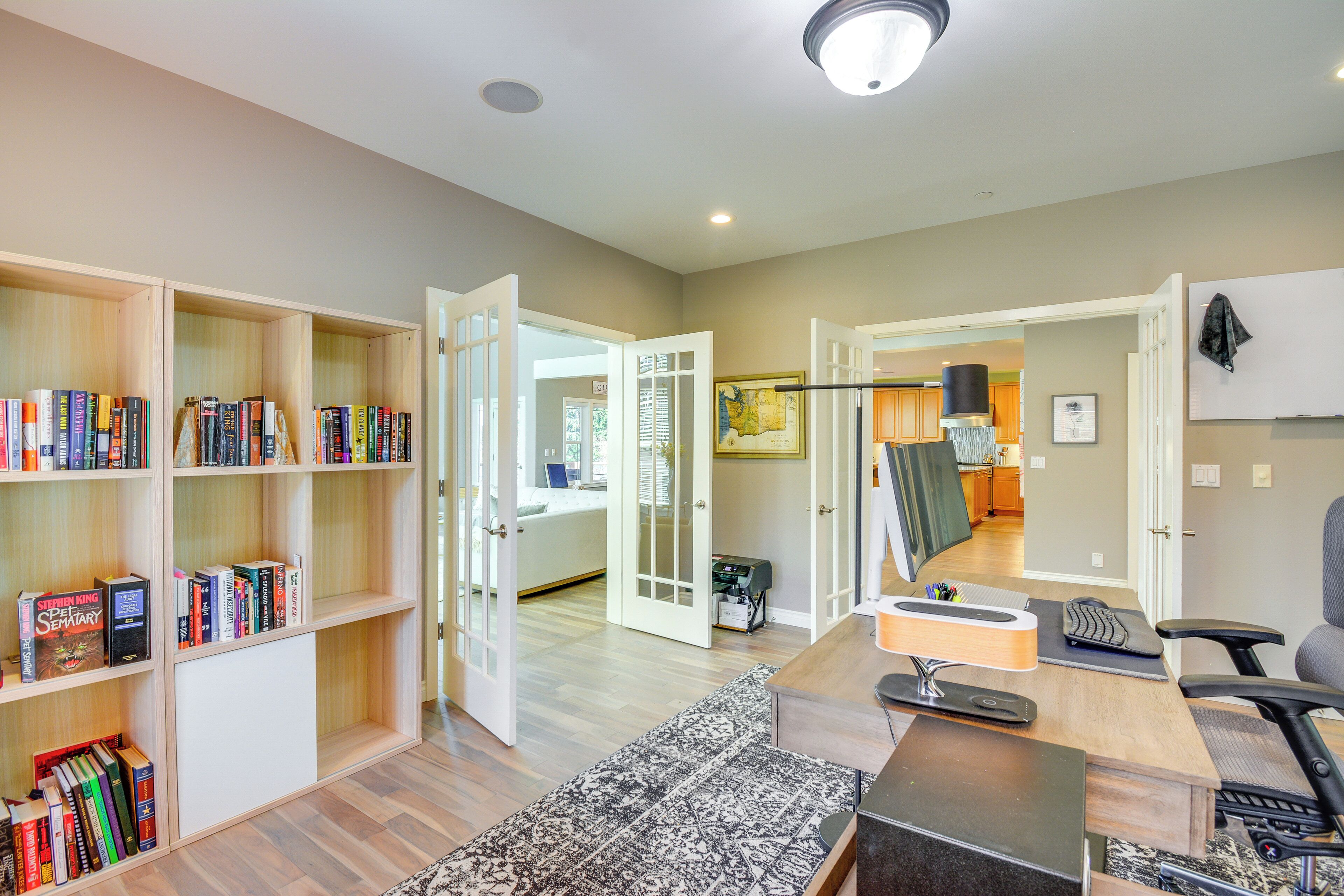 A spacious living area with a large bookshelf, a desk with a computer, and a comfortable seating area.