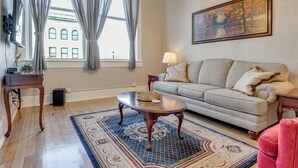 A living room with a sofa, a coffee table, a rug, a lamp, and a painting on the wall. - Historic Lebanon Gem: Central Walkable Location! (Lebanon)