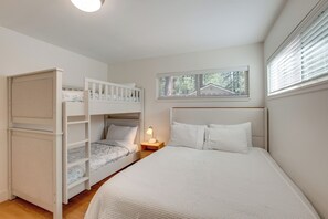 A bedroom with a bunk bed, a single bed, a nightstand with a lamp, and a window with blinds. - Pet Friendly w/ Yard! Fully Updated Tahoe Home (South Lake Tahoe)