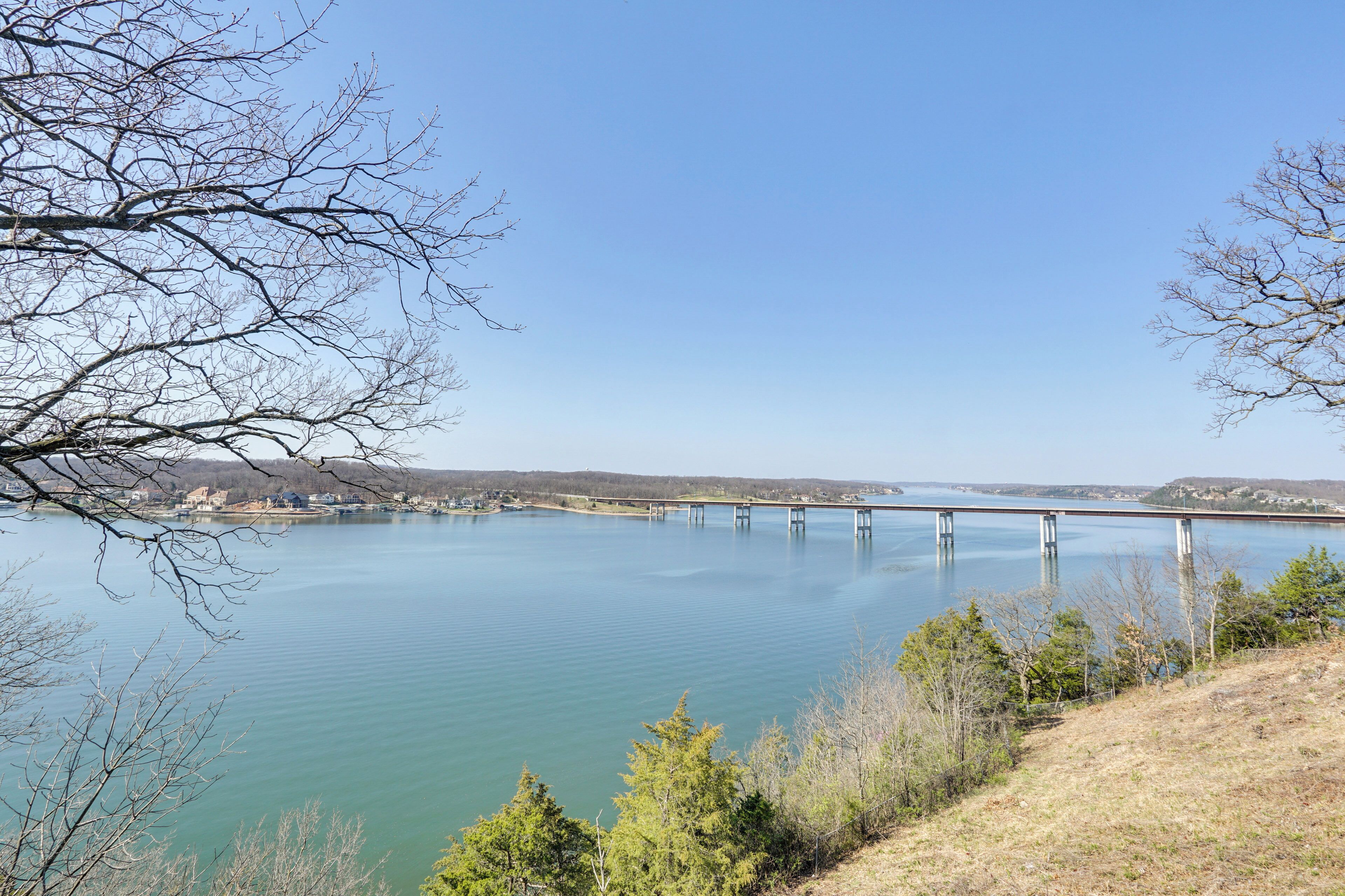 A bridge over a calm lake with clear skies.