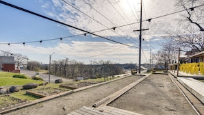 A wooden deck with a dirt path, utility poles, and a distant view of a road and buildings. - Main-channel Views for Lake Ozark Shootout Weekend (Lake Ozark)