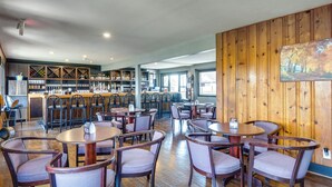 A restaurant with wooden walls, a bar area, and multiple seating arrangements. - Main-channel Views for Lake Ozark Shootout Weekend (Lake Ozark)