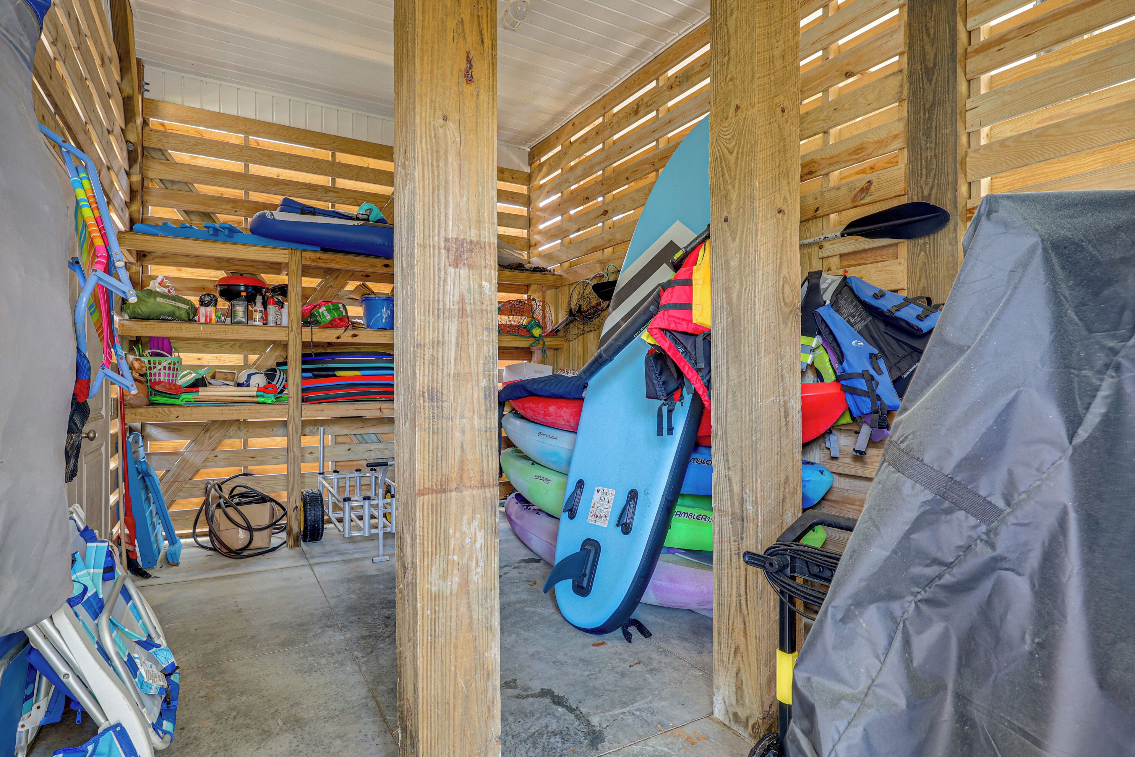 A storage area with various kayaks and water sports equipment.