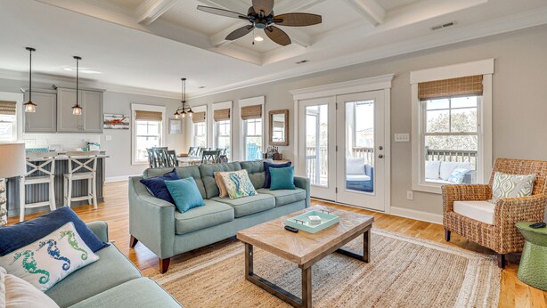 A spacious living room with a sofa, coffee table, and a ceiling fan. - Spacious Coastal Gem on Oak Island 100 Yds to Sand (Oak Island)