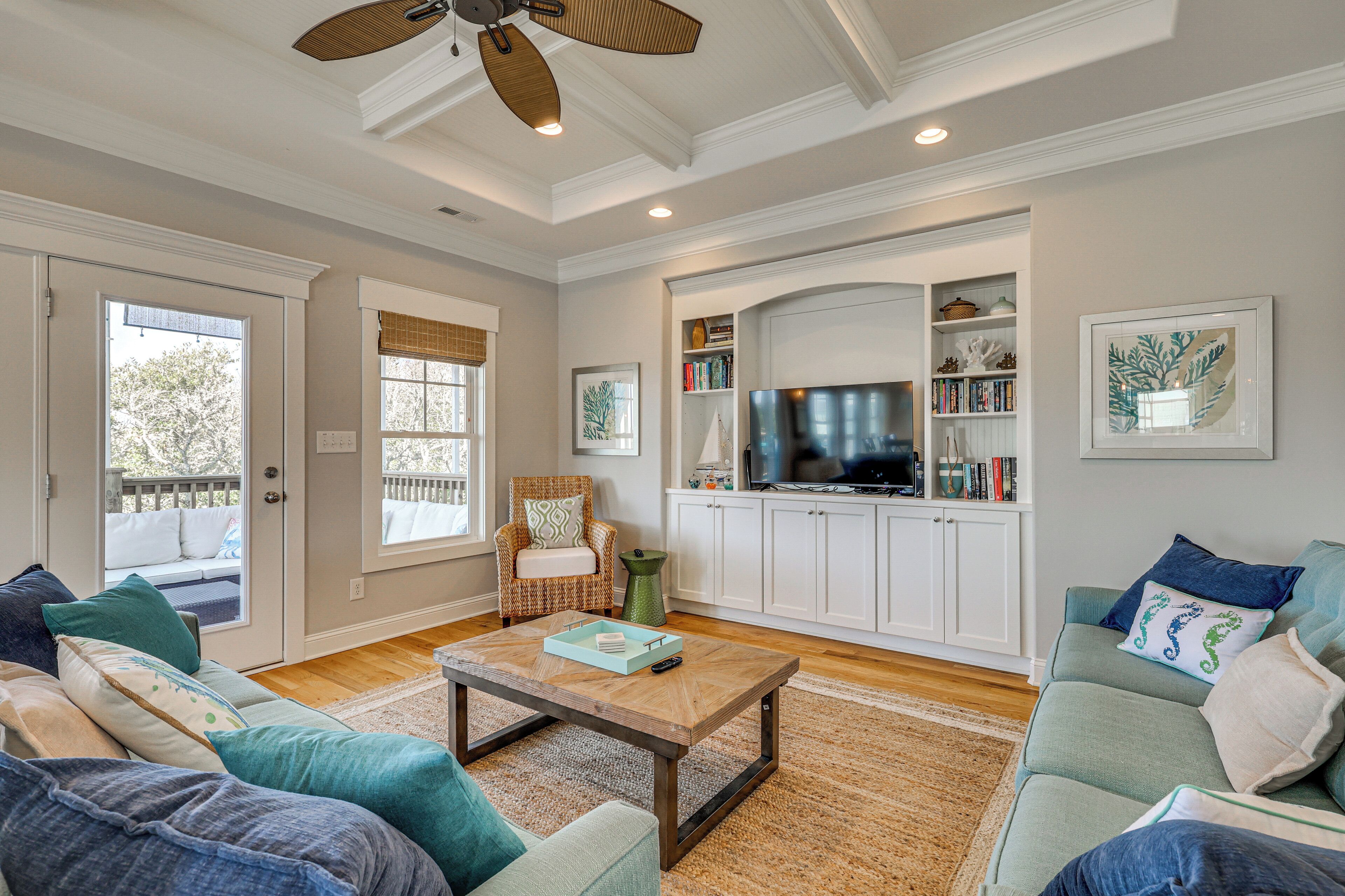 A living room with a sofa, coffee table, and a television.