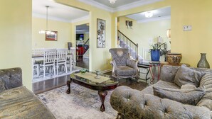 A living room with a chandelier, a dining area with a white table and chairs, and a staircase. - 8 Mi to Dtwn & Film Sites! Spacious Covington Home (Covington)