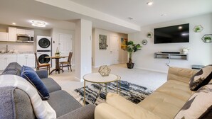 Un salon moderne avec un canapé, une table basse et un téléviseur fixé au mur.