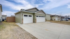 A two-story house with a garage, a front yard, and a driveway.