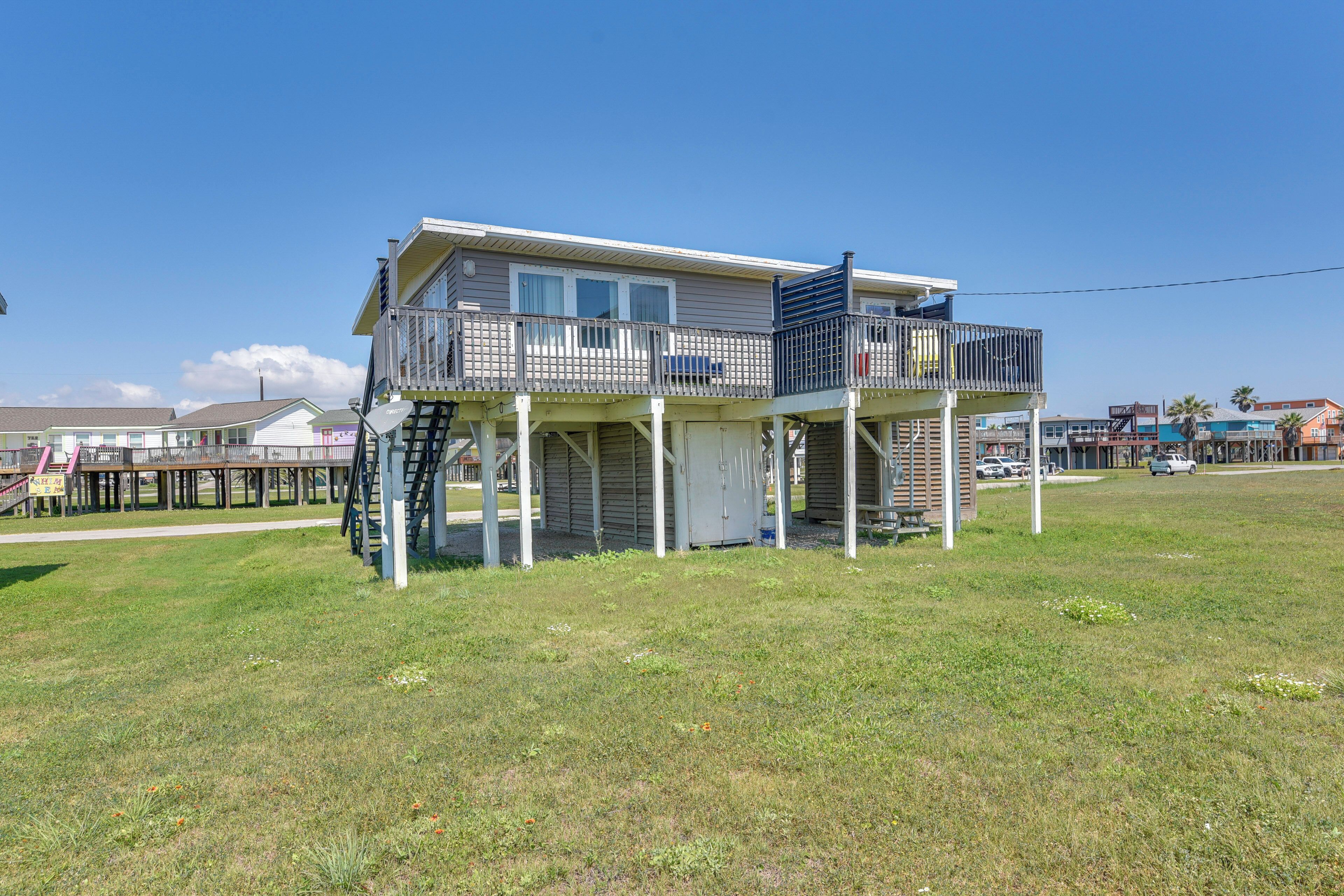 A two-story house with a balcony, a covered porch, and a small deck.