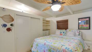 A bedroom with a bed, a ceiling fan, a wall clock, and a poster.