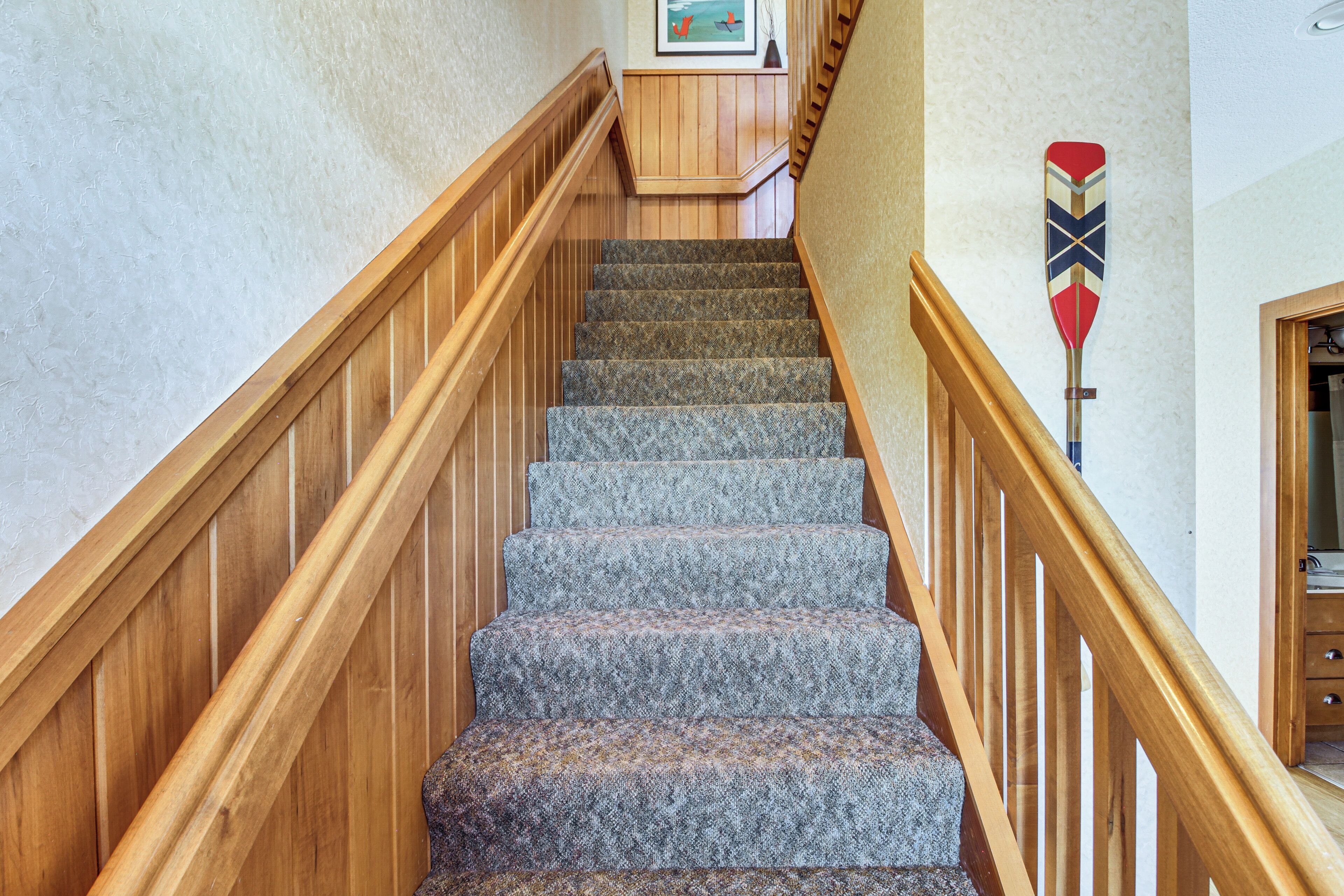 A staircase with wooden railings and carpeted steps.