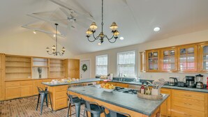 A spacious kitchen with a central island, wooden cabinets, and a chandelier. - 4 Mi to Noannet Pond: Pet-friendly Home w/ Yard (Dover)