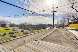 A wooden deck with a metal railing, a clear sky, and power lines overhead. - Unit 1: Pool Days & Lake Views on Bagnell Strip (Lake Ozark)