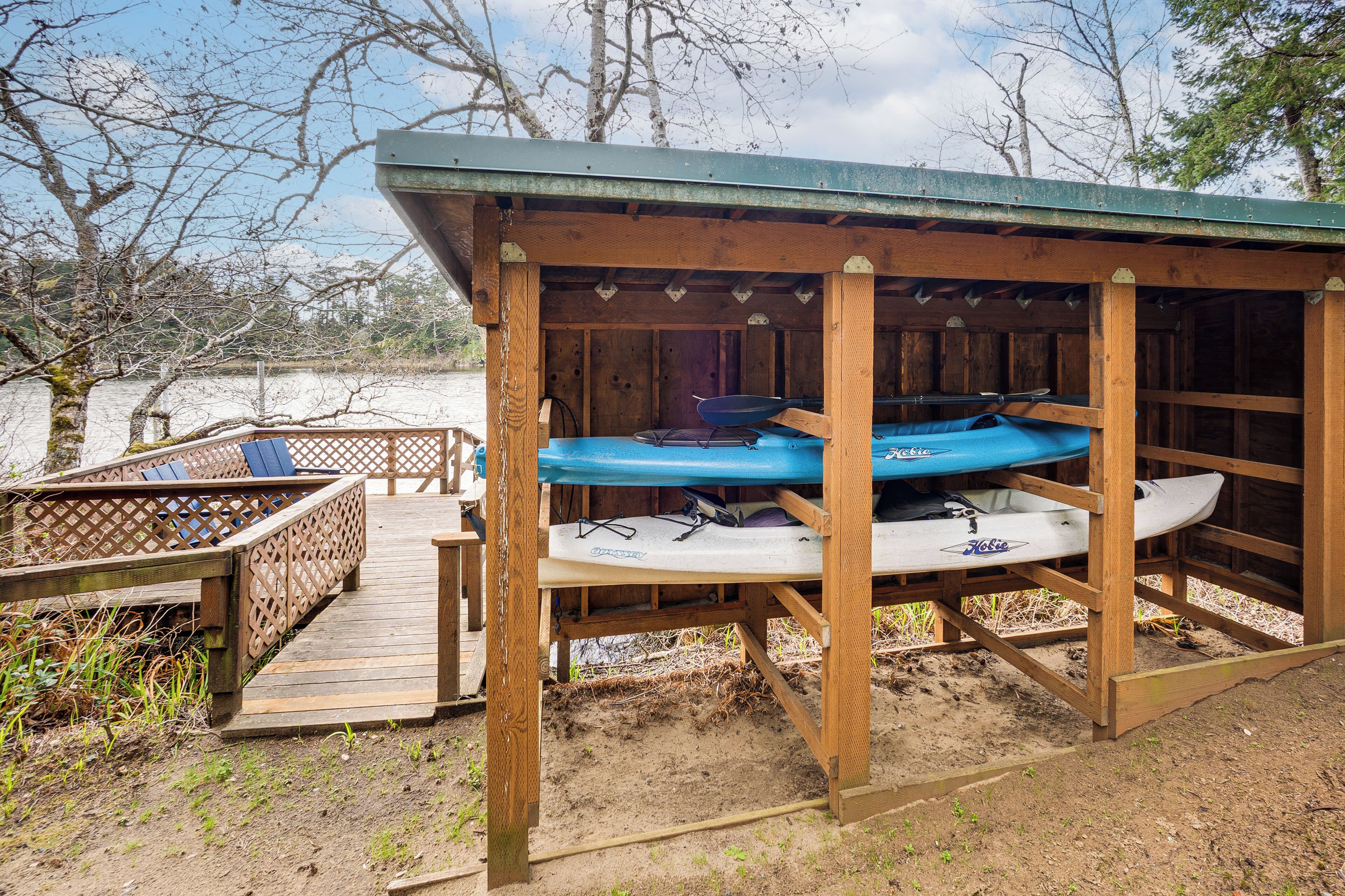 A wooden structure with kayaks and a covered seating area.