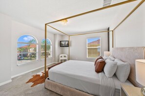 Ein Schlafzimmer mit Himmelbett, großen Fenstern und Blick ins Freie.