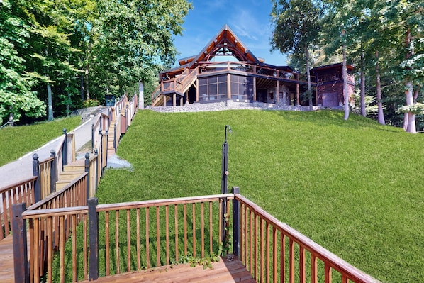 Ein modernes Haus mit einer Holzdachterrasse und einem Steinfundament.