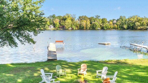 A lakeside setting with a dock, chairs, and a fire pit. - Lake Access Home on Cross Lake: Walk to Dtwn! (Pine City)