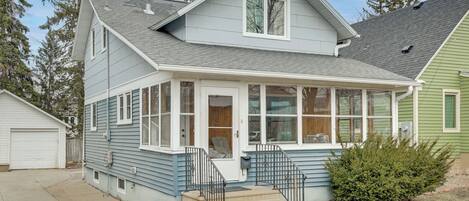 A two-story house with a covered porch, a front door, and a small front yard.