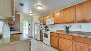 A kitchen with wooden cabinets, a microwave, a stove, and a refrigerator. - Shop & Dine! Getaway 3 Mi to Old Town Scottsdale (Scottsdale)