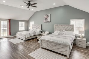 A bedroom with two beds, a ceiling fan, and a large window with blinds. - Indoor Hot Tub & Sauna! Spacious Catskills Home (Cairo)