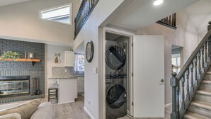 A modern kitchen with a brick wall, a built-in oven, and a dining area with a bar stool. - Renovated Townhome w/ Garage, 12 Mi to St Louis (Belleville)