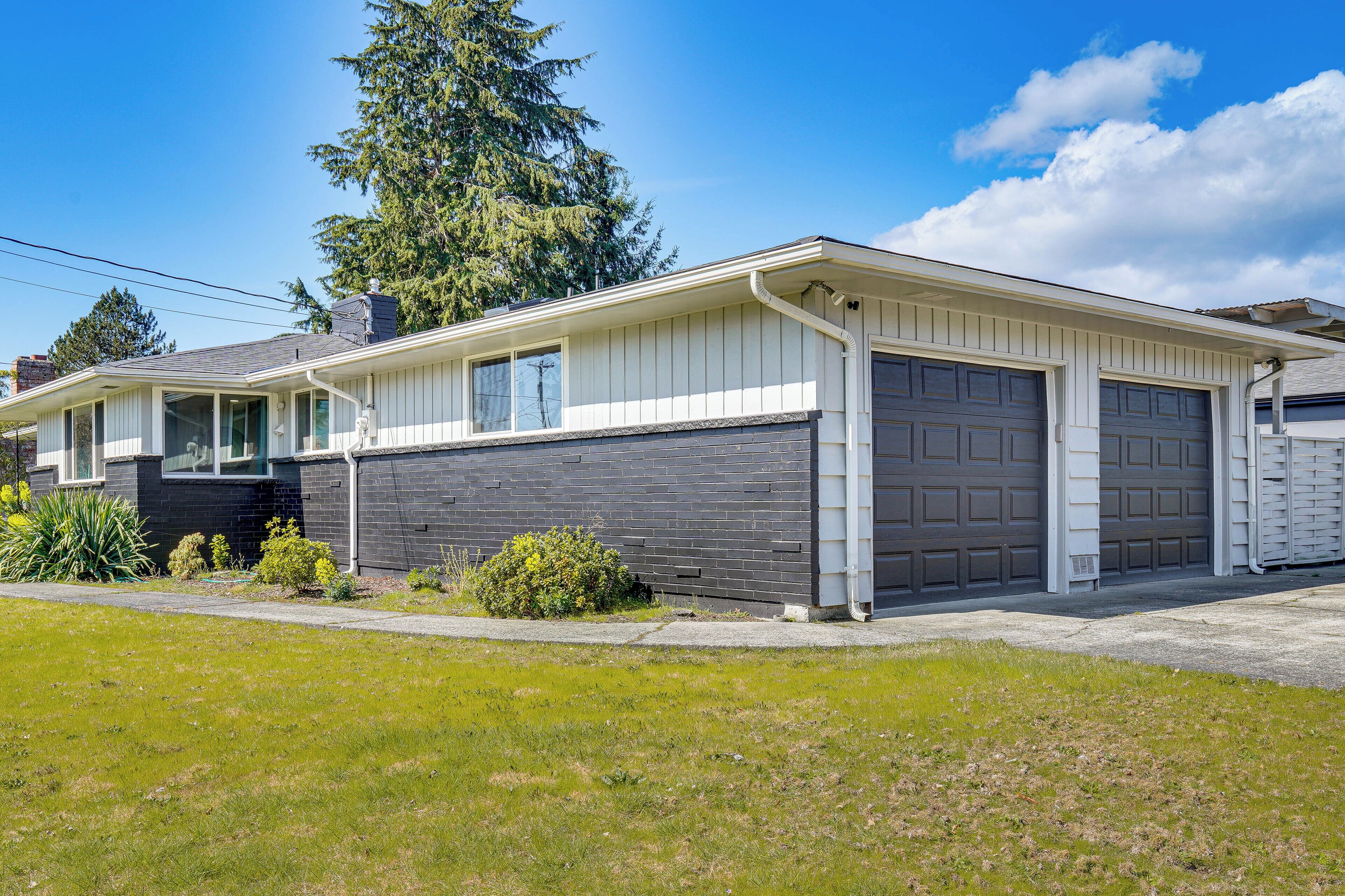A single-story house with a garage, a covered porch, and a well-maintained lawn.