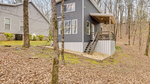 A two-story house with a covered porch and a staircase leading to the upper level. - Nature Stay By Guntersville Lake! Cozy Guest Cabin (Grant)