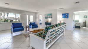 A spacious living room with a white sofa, blue armchairs, and a patterned bench. - 2 Mi to Englewood Beach! Home w/ Private Dock (Englewood)