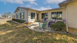 A modern house with a patio, two chairs, and a small garden. - 2 Mi to Englewood Beach! Home w/ Private Dock (Englewood)