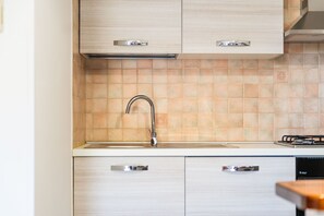 A kitchen with a modern design, featuring light-colored cabinets, a stainless steel faucet, and a tiled backsplash. - Casa Ale Villasimius: Cozy Two-Level Home for 4 Guests Near Beaches and Services (Villasimius)