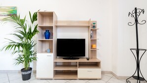 A TV stand with shelves, a drawer, and a potted plant. - Casa Ale Villasimius: Cozy Two-Level Home for 4 Guests Near Beaches and Services (Villasimius)