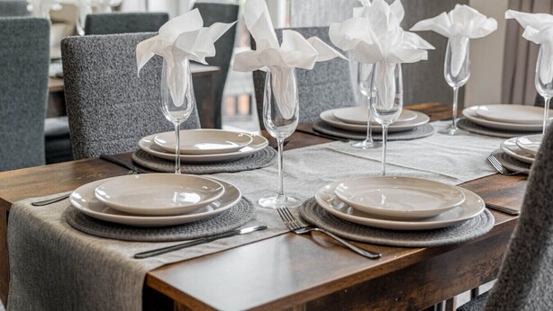 A dining table set with plates, cutlery, and napkins. - The Catalina Breeze - By the harbour, park and town with parking (Dorset)