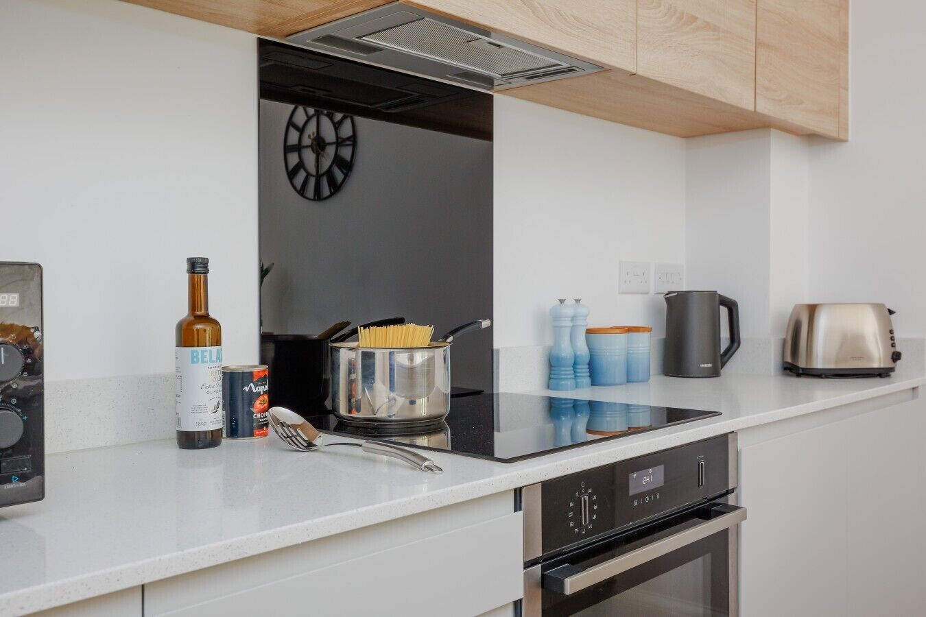 A modern kitchen with a built-in oven, a coffee maker, and a toaster.