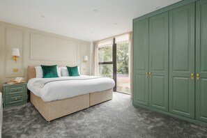 A bedroom with a bed, bedside tables, a wardrobe, and a window.