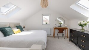 A bedroom with a bed, a desk, a dresser, a mirror, a window, and a skylight. - Tower Hide - 1 bed with parking (Boscombe)