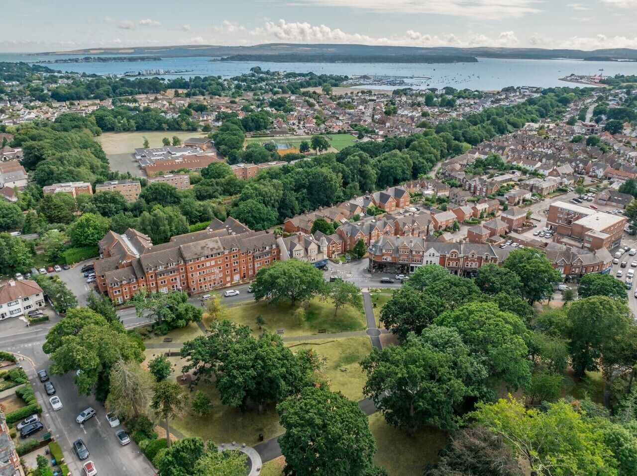 Luchtbeeld van een woongebied met huizen, wegen en een waterpartij op de achtergrond.