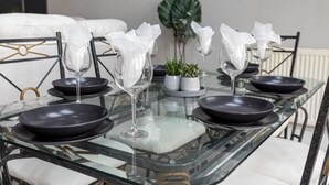 Une table à manger avec des assiettes noires, des verres à vin transparents et des serviettes blanches.