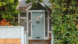 A house with a light blue door, a brick wall, and a small garden area. - Beaufort Heights - Well located for Christchurch and the beaches (Dorset)