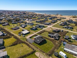 Luftaufnahme eines Wohngebiets mit H äusern, Straßen und einem Strand.