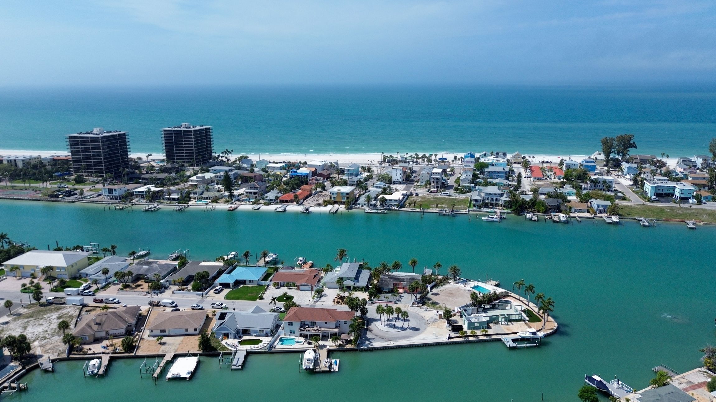 A coastal town with a marina, beachfront, and high-rise buildings.