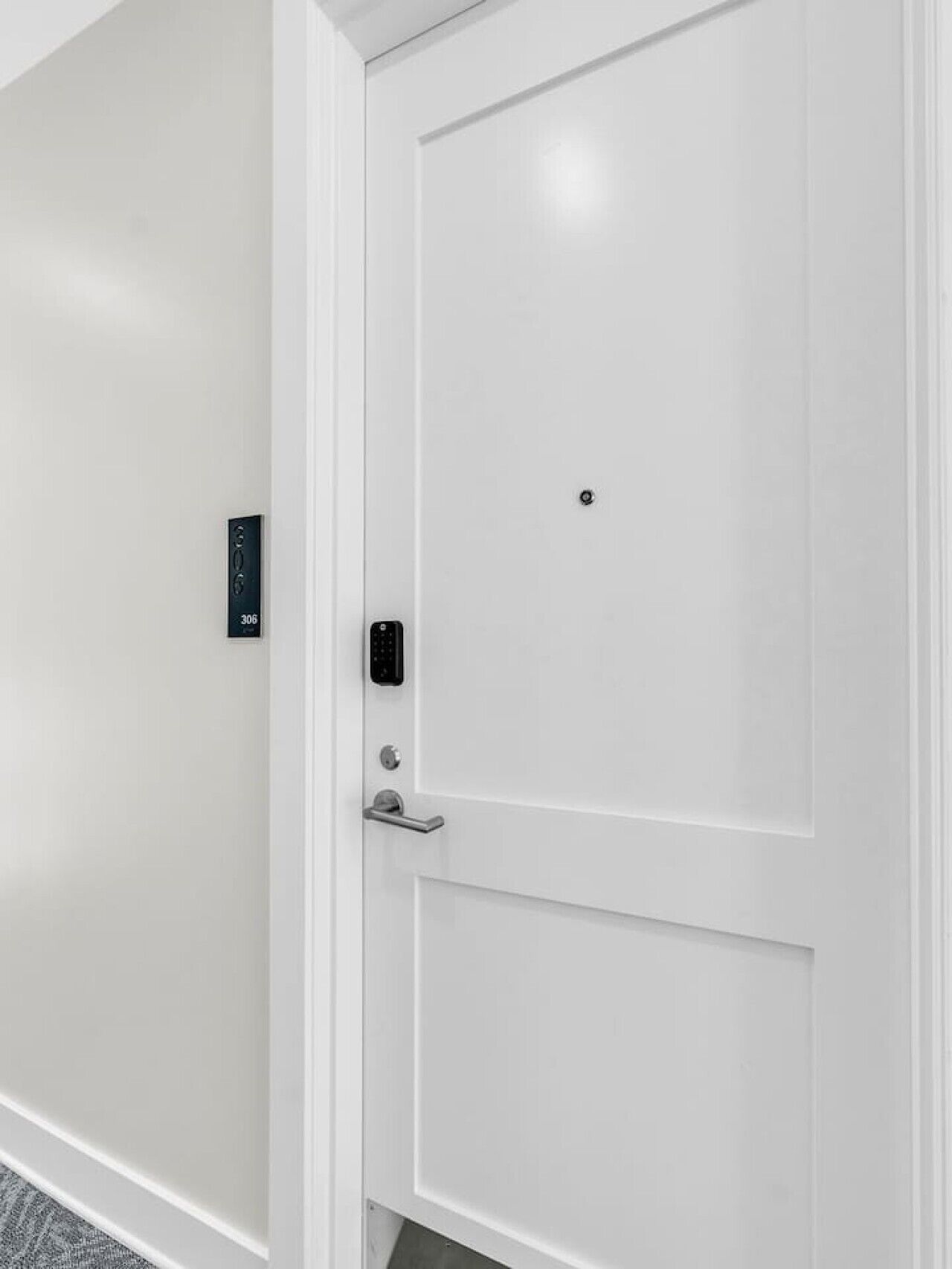 A white door with a keypad lock and a doorbell.