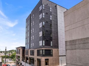 A multi-story building with a modern architectural design, featuring a mix of glass and concrete facades. - Lone Tree Pass | King + Queen | Balcony + Parking (Knoxville)