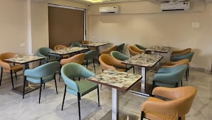 Ein Konferenzraum mit Tischen, Stühlen, Deckenventilatoren und Klimaanlagen.
