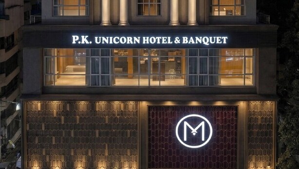 Ein mehrstöckiges Hotel mit klassischer Architektur, mit beleuchteter Beschilderung und einem markanten Eingang.