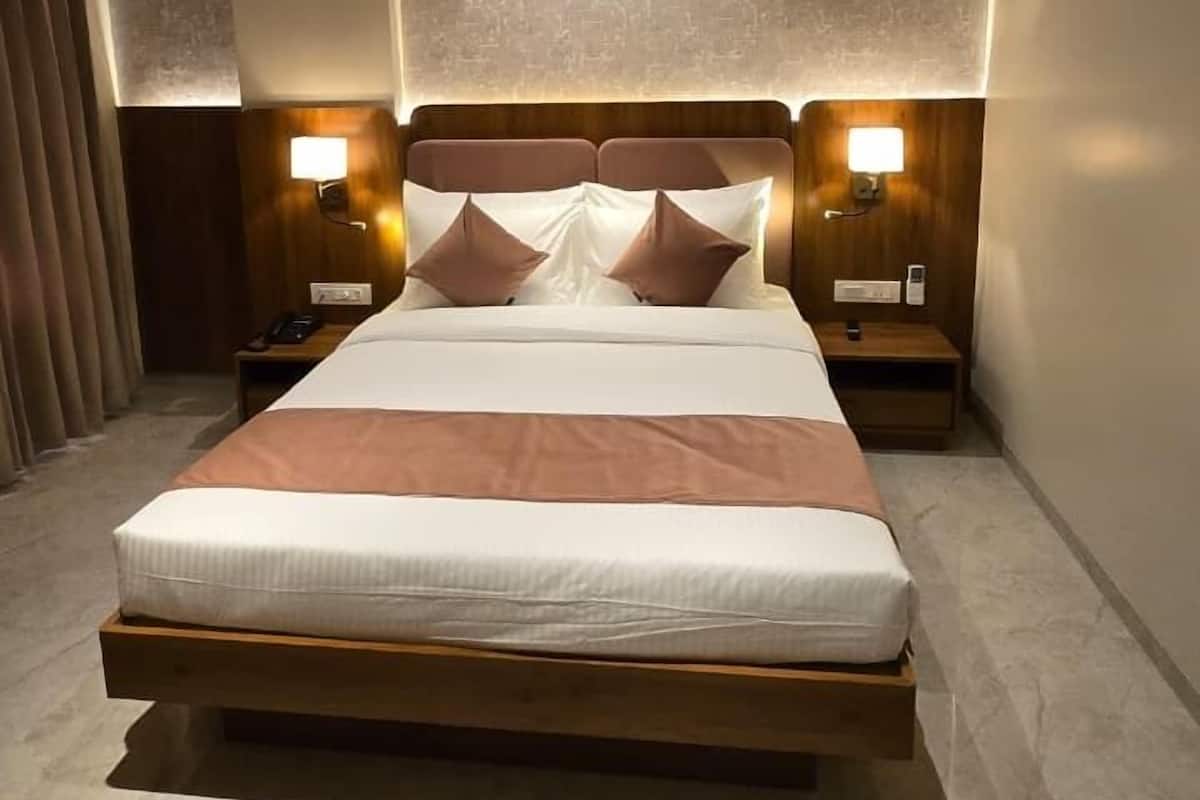 Ein modernes Hotelzimmer mit einem großen Bett, Nachttischlampen, einem Deckenventilator und einer strukturierten Wand.