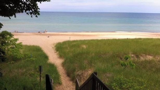 A beach view with a wooden staircase leading down to the sand. - The Nordic cottage, huge modern pool, hot tub. (Union Pier)