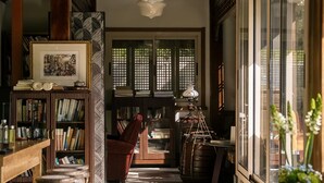 A wooden interior with bookshelves, a red chair, and a table.